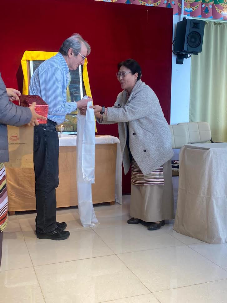 Secretary Chime Tseyang presenting a ceremonial white scarf to the tutor of Sager Nun’s Science Leadership Programme.