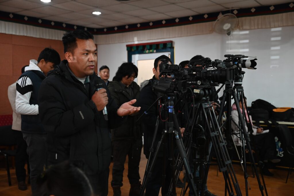 A media person asking a question to the speakers during the press conference.